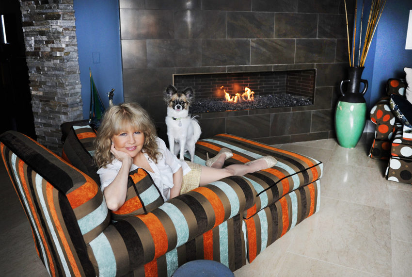 A woman and her dog are laying on the couch.