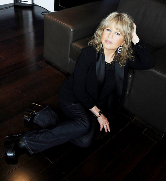 A woman sitting on the floor in front of a couch.